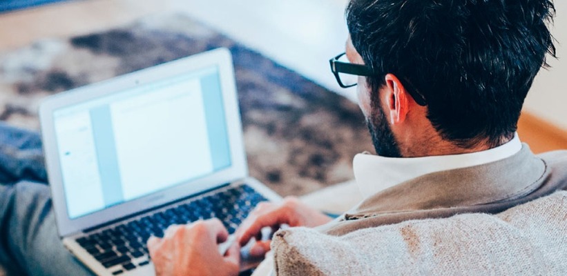 a man working on his laptop on a couch