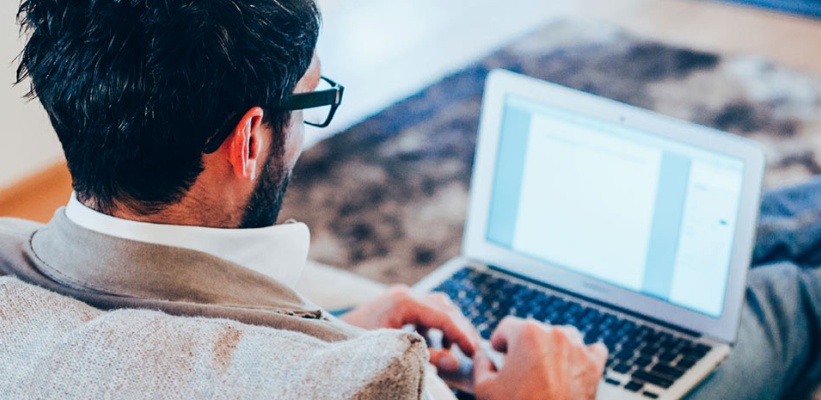 a man working on his laptop on a couch