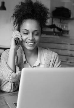 a woman with her mobile device and viewing her laptop