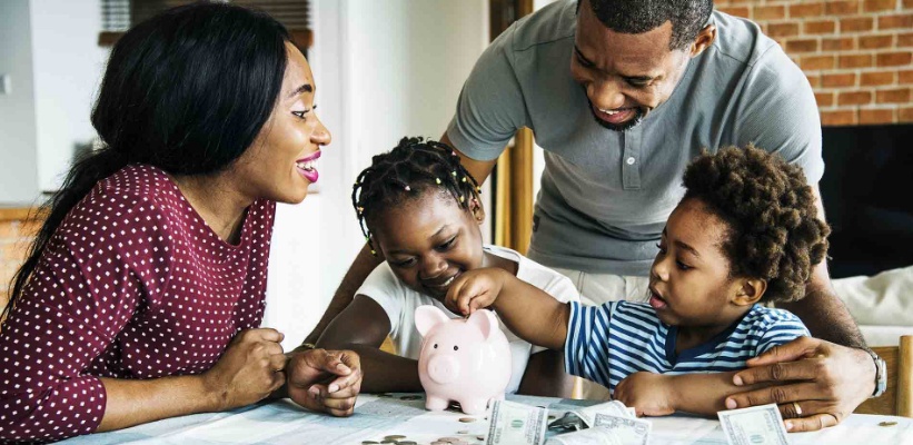 a family putting money in a piggy bank